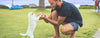 bearded, tattooed man playing with puppy